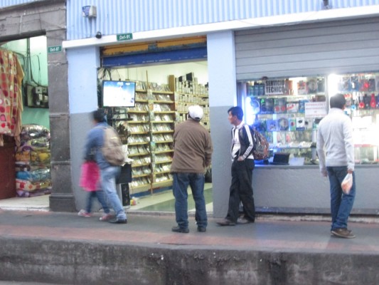 La photo est floue, mais ces Équatoriens regardent un DVD de la WWE, à l'extérieur d'un commerce de Quito.